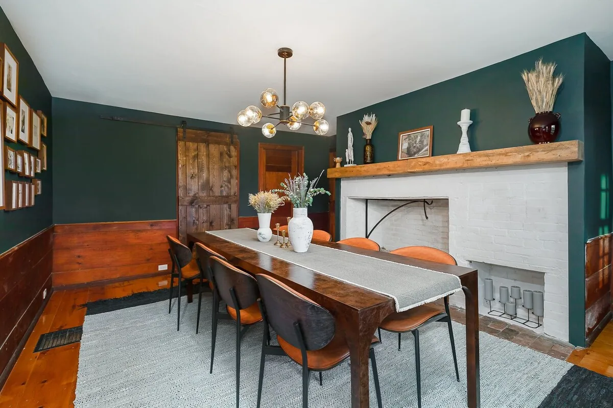 Formal dining room with a long table and original fireplace