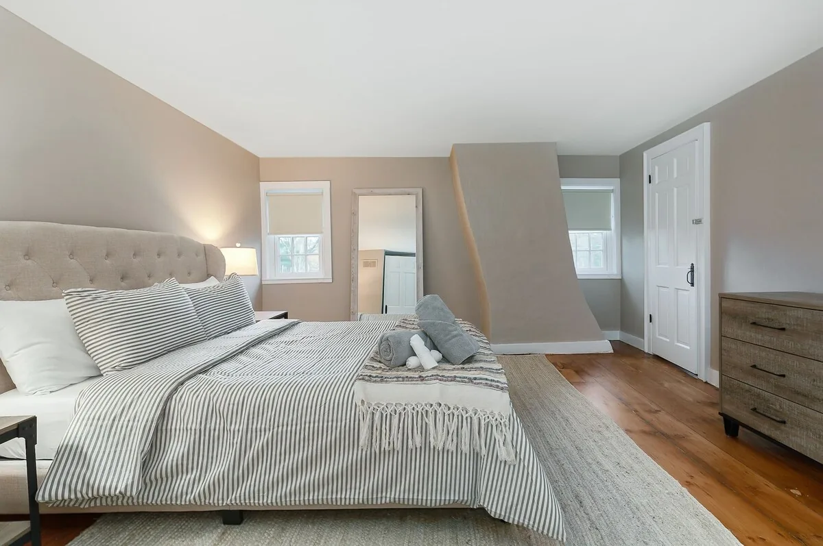 Bright bedroom with a striped upholstered bed and dresser