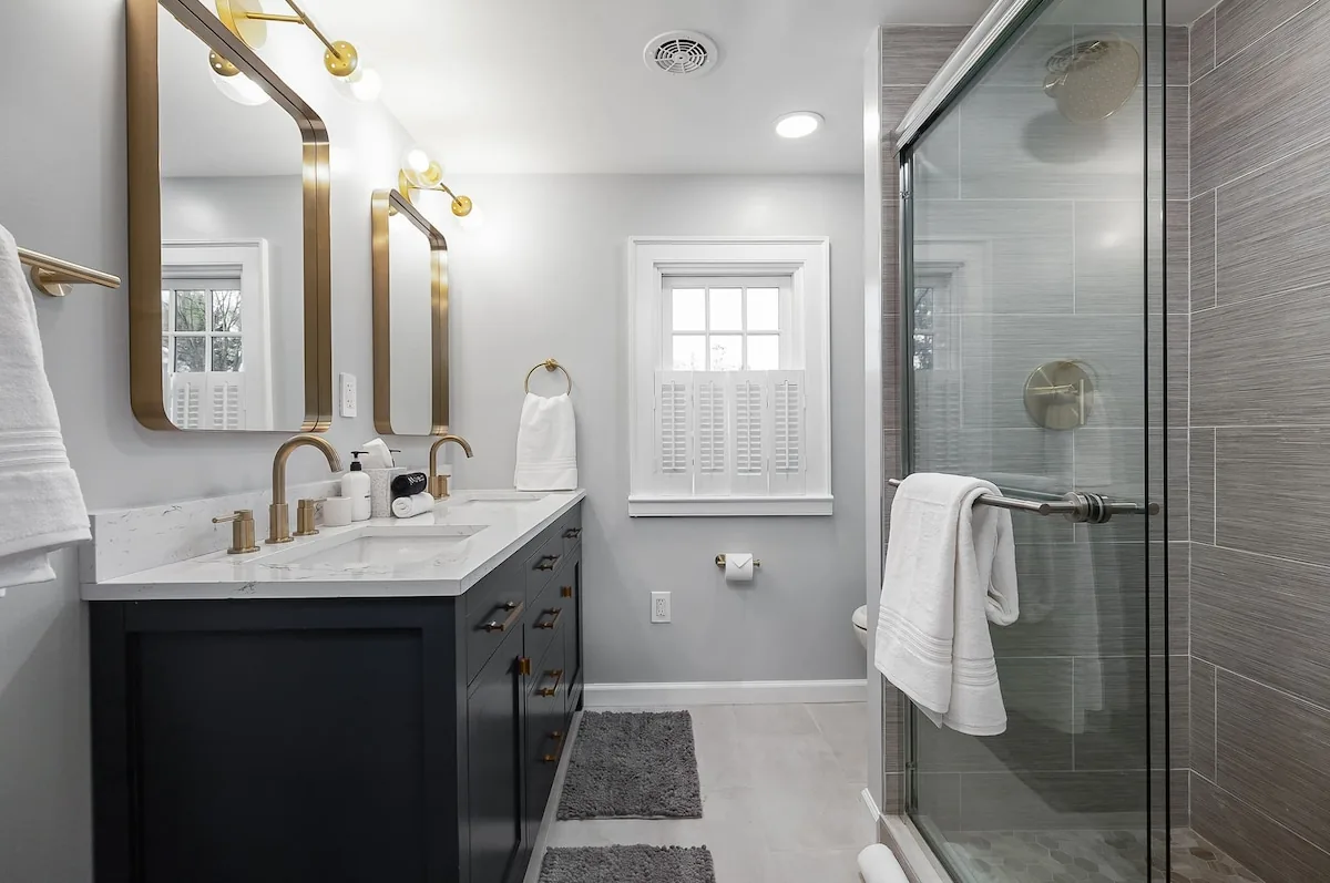 Renovated bathroom with a double vanity and glass shower