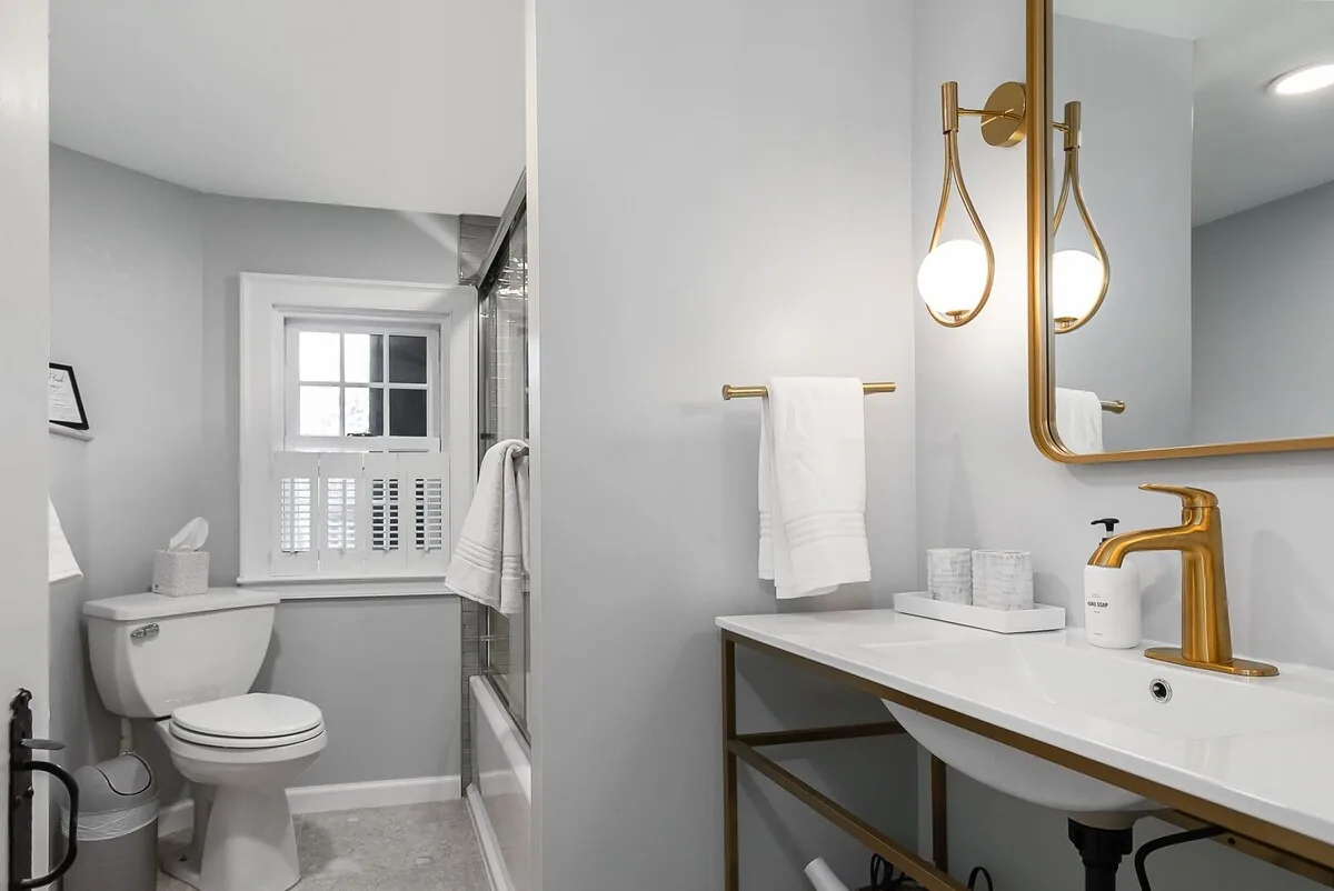 Bright full bathroom with brass fixtures and a tub shower