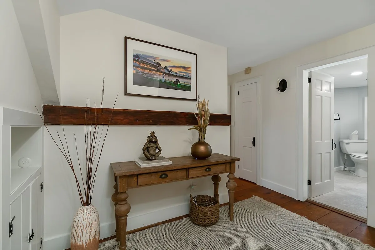 Farmhouse hallway with antique console and bright doorway