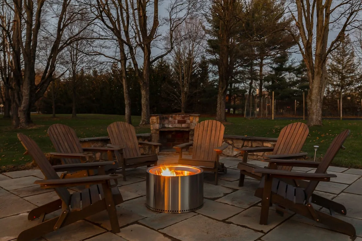 Adirondack chairs gathered around the outdoor fire pit