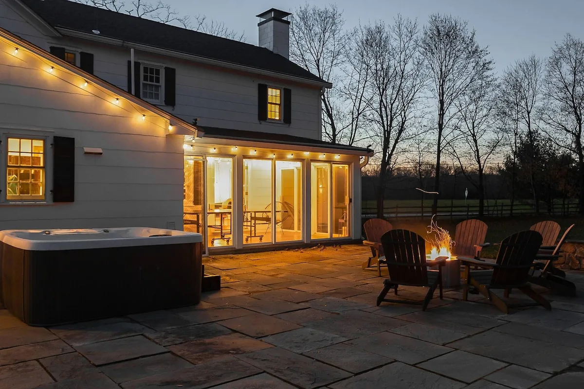 Farmhouse patio, hot tub and fire pit at dusk