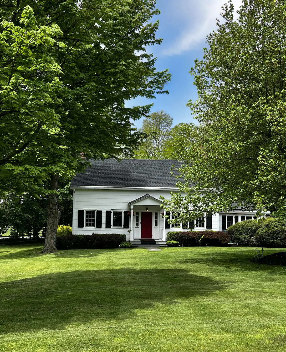 Farmhouse seen across the sweeping lawn