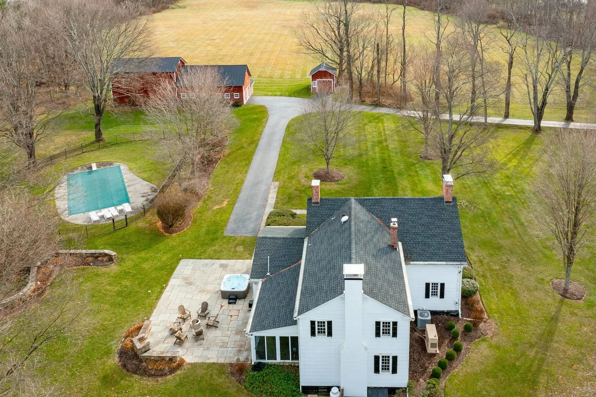 Aerial view of the farmhouse, patio, pool and grounds