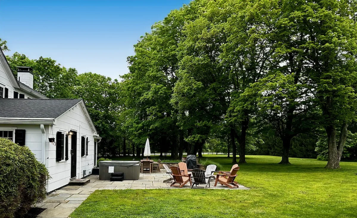 Back patio and broad lawn beneath mature shade trees